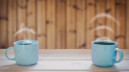 Two coffee cup concepts on a wooden table Smoke is volume icon.の写真素材