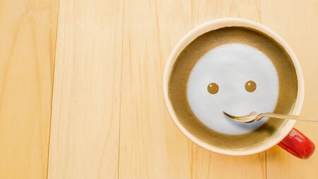 Froth milk foam smiles in a cup of coffee in morning.の写真素材