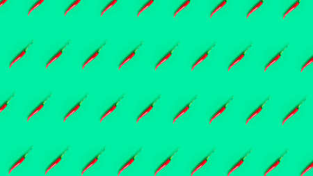 Flat lay composition with red hot chilli peppers pattern on green background.の写真素材