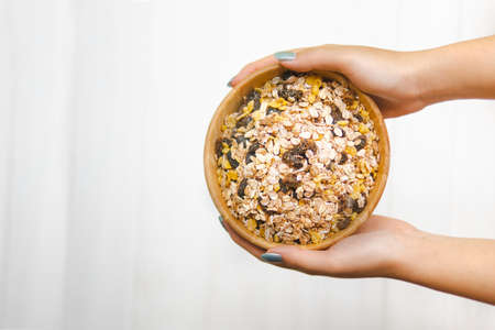 hand woman holding muesli in wood cupの写真素材