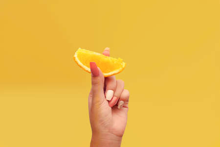 Women's hand shows one piece of orange