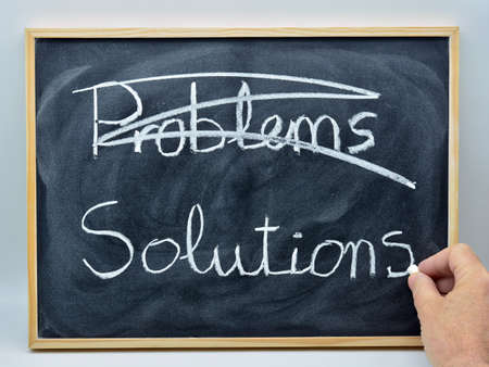 the words problems and solutions written in English, on a blackboard with a chalkの写真素材