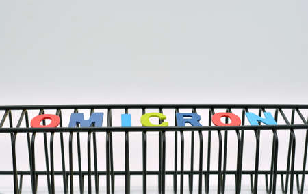 The word omicron, a variant of the covid 19 virus, on a fence, like a cage