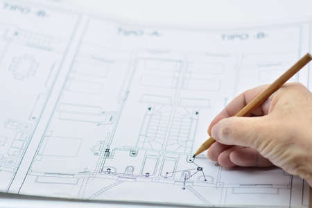Hand drawing with a pencil on an architectural plan of a house