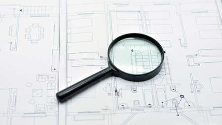 Concept of looking at a blueprint with a magnifying glass, architectural project