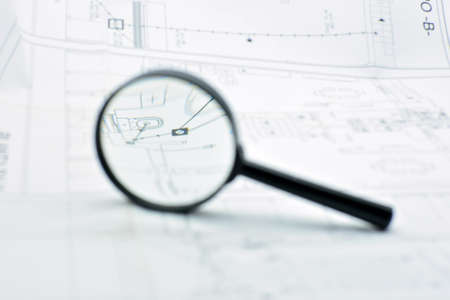 Concept of looking at a blueprint with a magnifying glass, architectural projectの写真素材