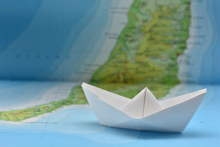 Paper boat on the water painted from a blurred mapの写真素材