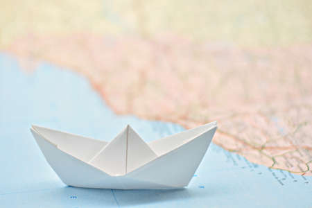 Paper boat on the water painted from a blurred mapの写真素材