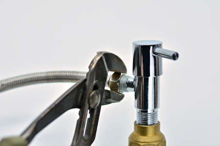 Pliers tightening the nut of a faucet, breakdownの写真素材