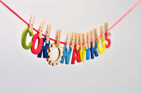 The word coronavirus made with wooden letters, on a clothesline caught with clothespinsの写真素材