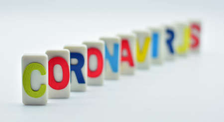Domino tiles placed with the word coronavirus, domino effectの写真素材