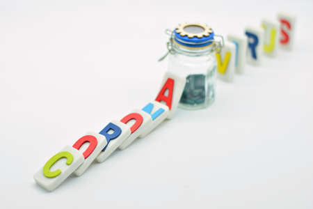 Fallen dominoes with the word coronavirus, cut by a bottle of pills, domino effectの写真素材