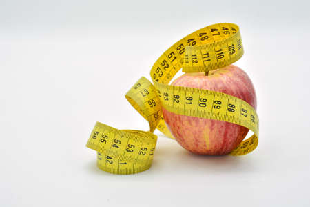 Apple wrapped with a tape measure, isolated on white background