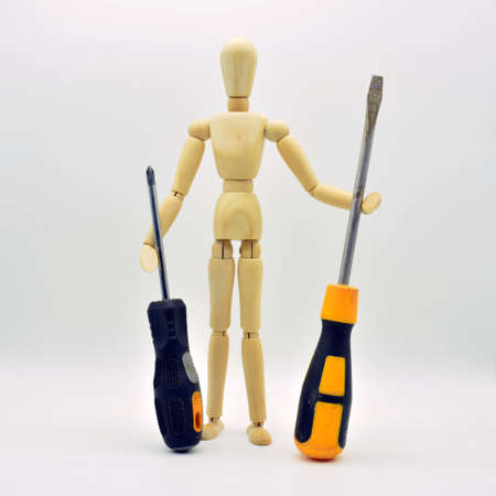 Wooden articulated mannequin with work tools, isolated on white background