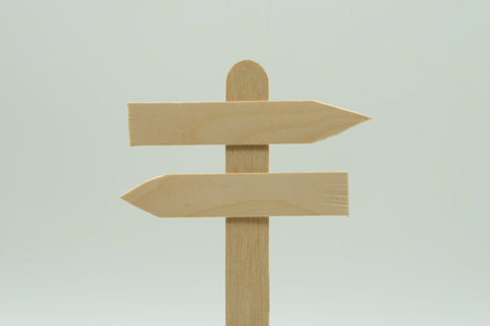 Wooden crossroad signpost with opposite arrows, on white backgroundの写真素材