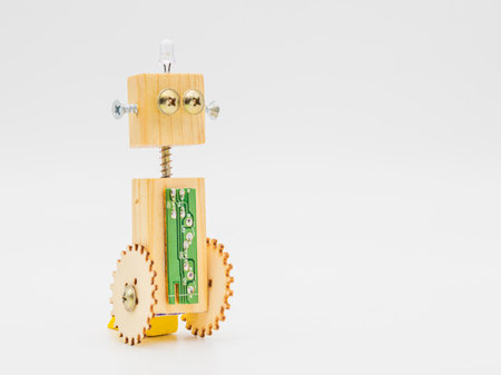 Small robot with wheels, made with wood and screws, isolated on whiteの写真素材