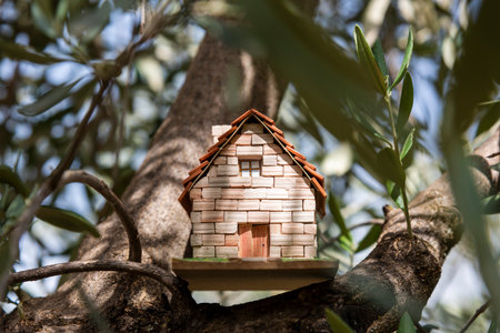 Handmade miniature house in the branches of a treeの写真素材