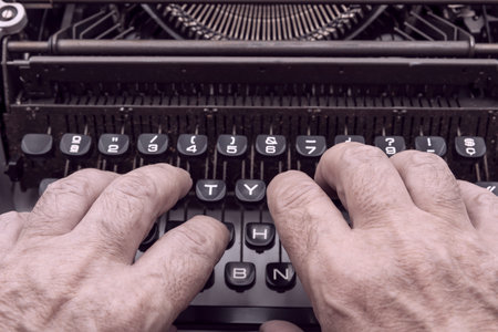 Hands typing on an old typewriterの写真素材