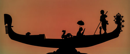 Silhouette of a Venetian gondola with gondolier and couple in love with warm backgroundの写真素材