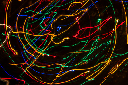 Bright colorful lights in motion with dark backgroundの写真素材