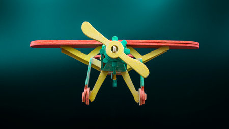 Wooden airplane with propeller, colorfully painted, isolated on black backgroundの写真素材