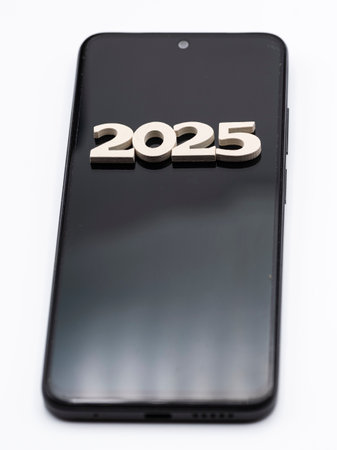 Mobile phone with the number 2025 on the screen, isolated on whiteの写真素材
