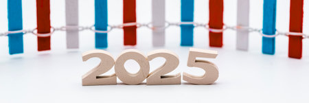 Number 2025 made of wood and a fence painted in blue, red and white in the backgroundの写真素材