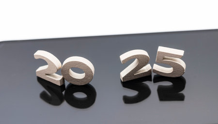 Mobile phone with detail of number 2025 on the screen, isolated on white