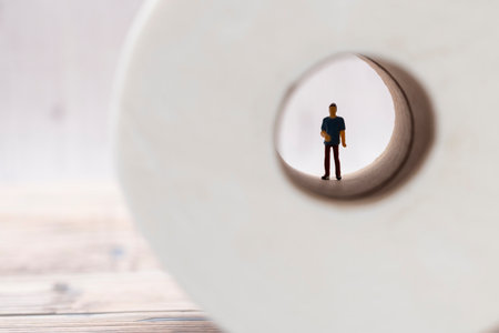 Miniature figure of a man inside a toilet paper roll