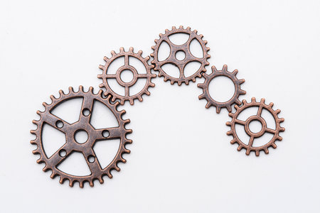 Metal gear wheels made of copper and bronze of different sizes, isolated on white