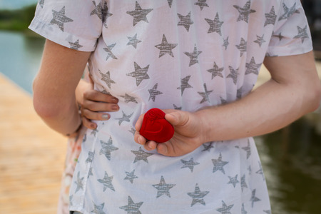 Man holds his back box with a wedding ring