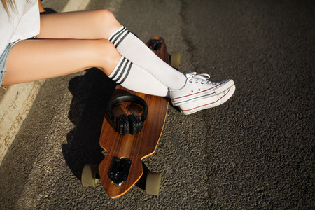 Girl rest on sidewalk after longboard rideの写真素材
