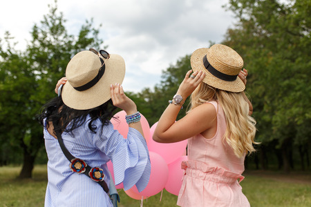 back of  two womans in hats looking forwardの写真素材