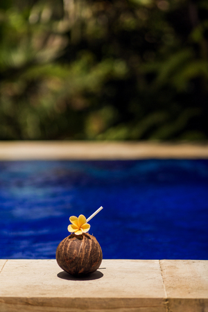 Coconut drink with yellow flower at poolside.の写真素材