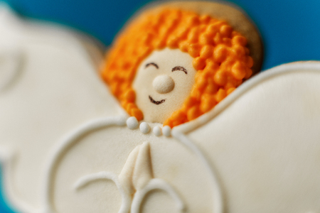 Angel gingerbread cookie on a blue background.の写真素材