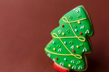 Christmas tree gingerbread on dark red background.の写真素材