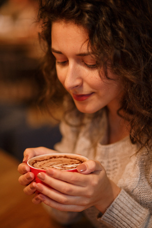 portrait of beautiful business girl drinking coffee from white cup in cozy restaurant.の写真素材