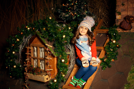 Cute little girl sits on the roof and wait for santa. Christmas decoration.の写真素材
