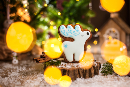 Holiday traditional food bakery. Gingerbread white christmas deer in cozy warm decoration with garland lights.の写真素材