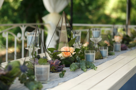 Florarium with fresh succulent and rose flowers festive table decoration. Event fresh flowers decoration. Florist workflow. Wedding ceremony design.の写真素材