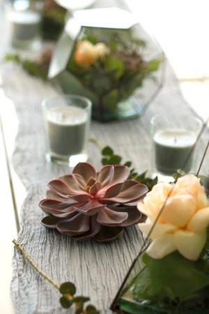 Florarium with fresh succulent and rose flowers festive table decoration. Event fresh flowers decoration. Florist workflow. Wedding ceremony design.の写真素材