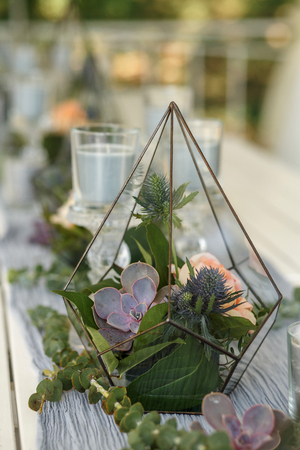 Florarium with fresh succulent and rose flowers festive table decoration. Event fresh flowers decoration. Florist workflow. Wedding banquet designの写真素材