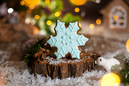 Holiday traditional food bakery. Gingerbread blue snowflake in cozy warm decoration with garland lights.の写真素材