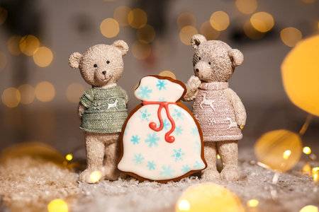 Holiday traditional food bakery. Gingerbread santa's bag of gifts and two decorative bears in cozy warm decoration with garland lights.の写真素材