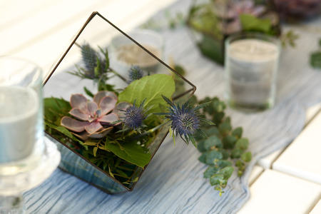 Florarium with fresh succulent and rose flowers festive table decoration. Event fresh flowers decoration. Florist workflow. Wedding ceremony design.の写真素材