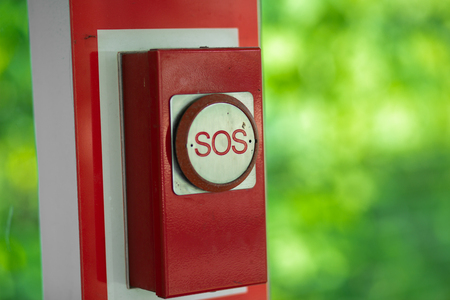 Old red emergency sos button in Kuala Lumpur park.