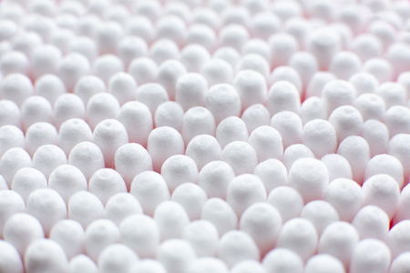 Closeup view from above on round pack of cotton buds on pink background.の写真素材
