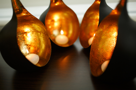 decorative round copper candlestick with burning candles inside.の写真素材