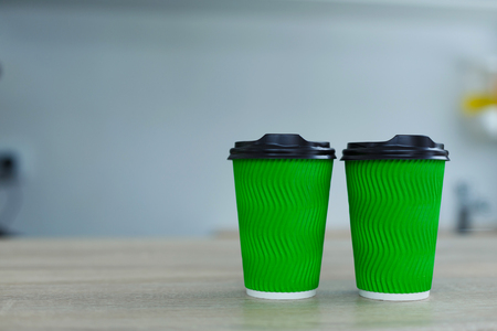 hot coffee in green takeaway paper cup. Coffee take away at cafe shop.の写真素材