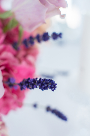 closeup bouquet of fresh roses and lavander on blue sky background. Event decoration with fresh flowers.の写真素材